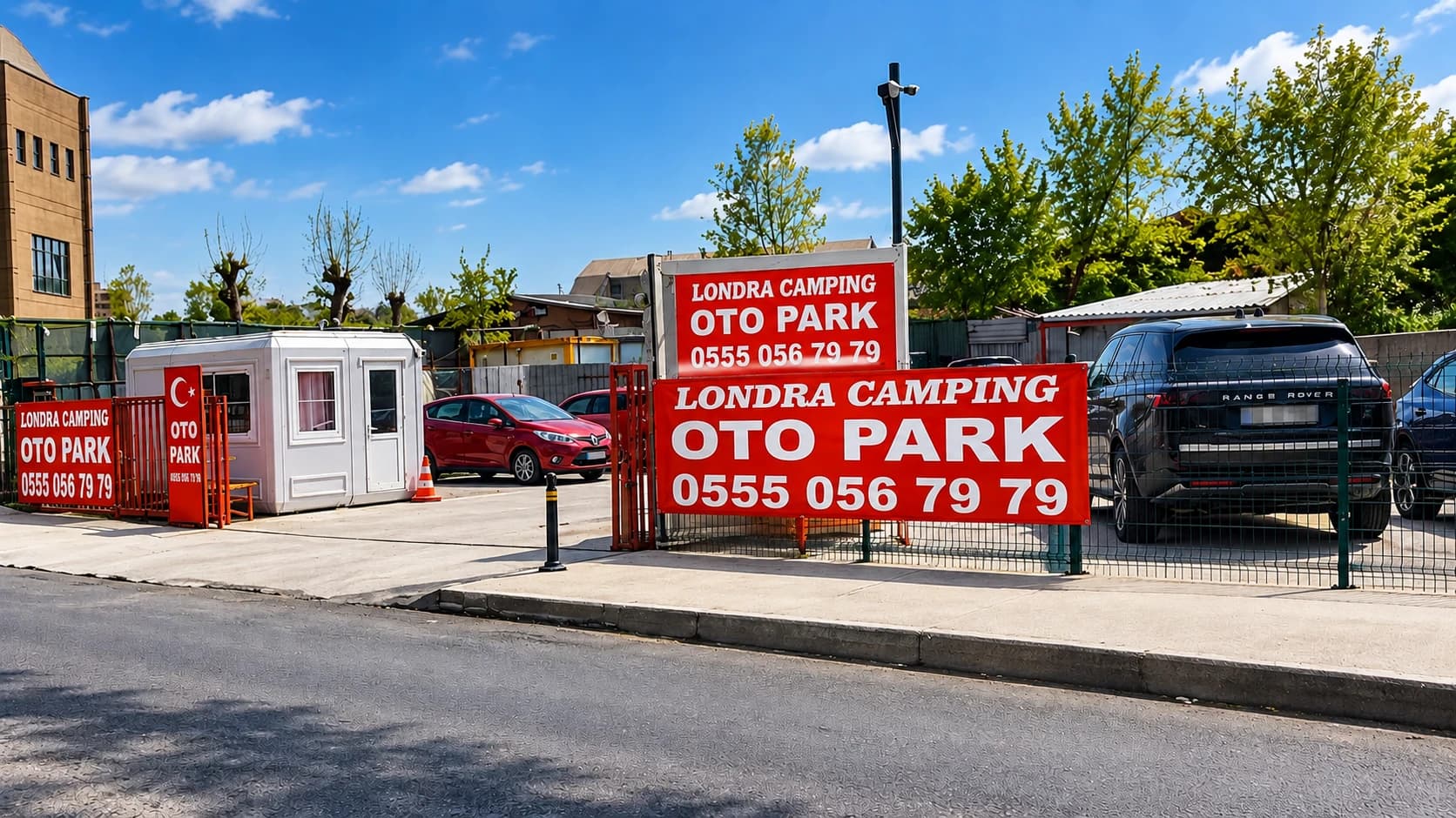 Londra Camping Otopark girişi: kırmızı Londra Camping Oto Park pankartları, beyaz güvenlik kulübesi, kamera direği ve tel çit